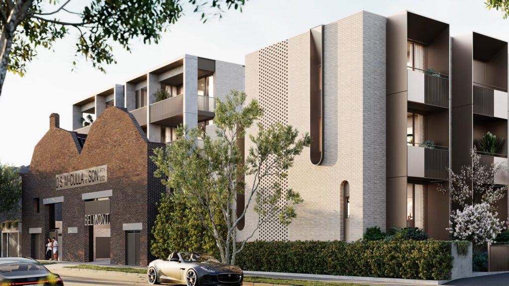 A modern apartment building with cream and light brown brickwork stands beside an older brick industrial-style structure that reads USF WOOLLEN STORE. A tree, landscaped greenery, and a parked convertible car line the street in front.